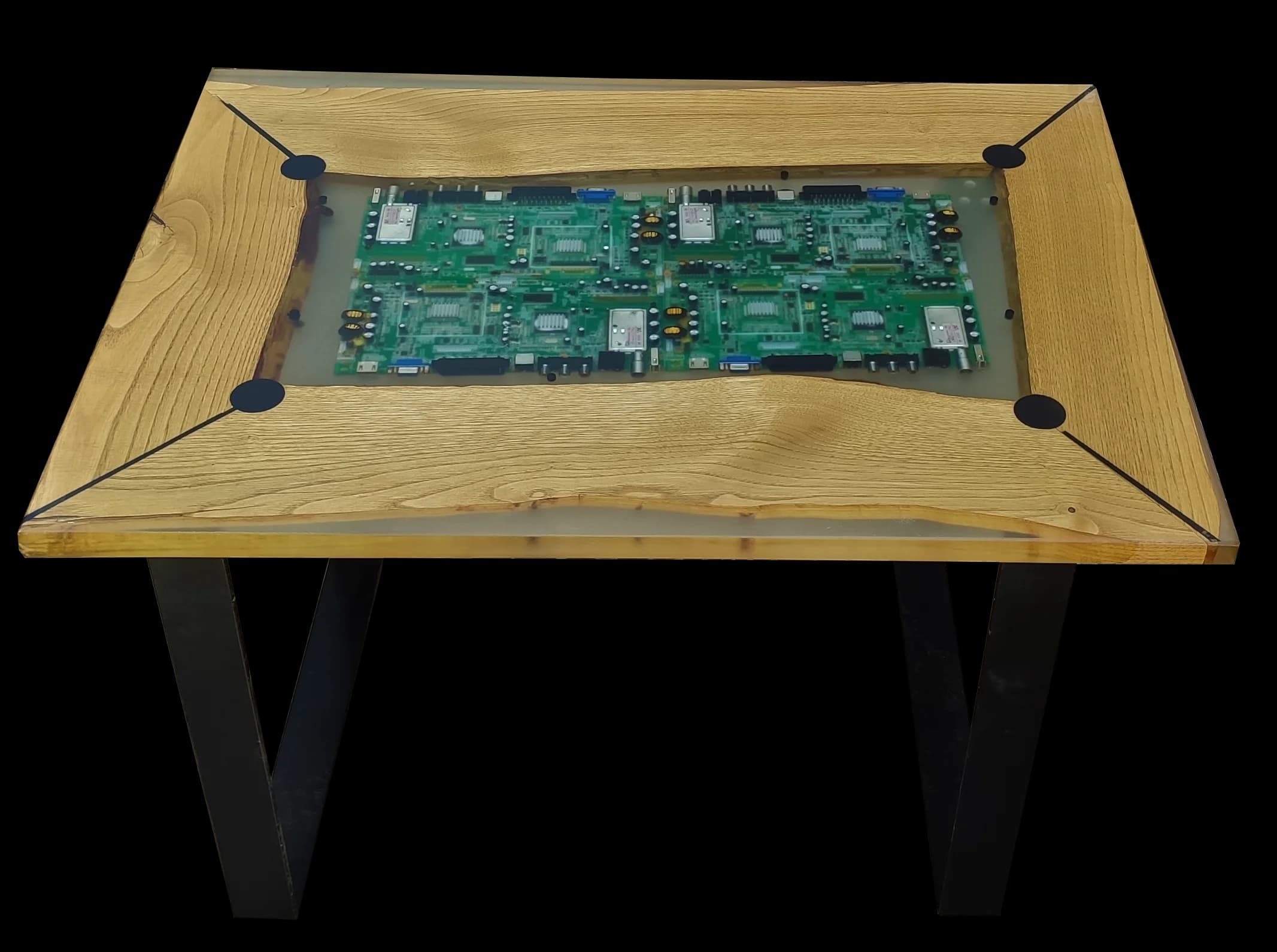 Mesa tecnológica con placas base de circuitos electrónicos encapsuladas en resina transparente sobre roble