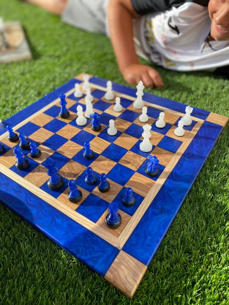 Tablero de ajedrez con resina azul vibrante y madera de olivo, pieza artesanal de Carpintería Cardiel