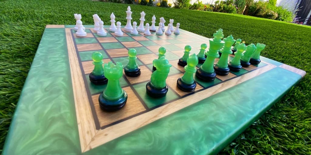 Tablero de ajedrez artesanal con resina verde esmeralda con efecto swirl y piezas verdes translúcidas, creado a mano en Binéfar