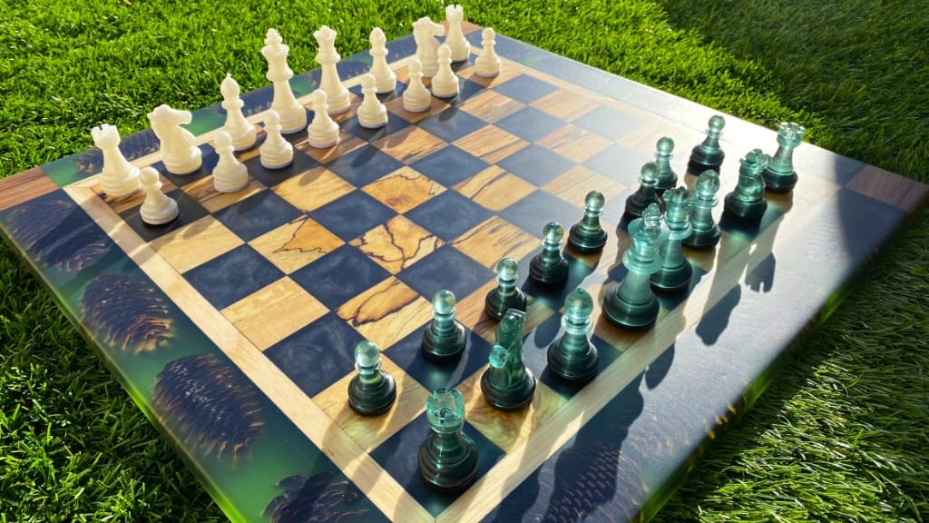 Tablero de ajedrez elegante de resina verde oscuro con piezas translúcidas y madera natural, pieza artesanal de Carpintería Cardiel